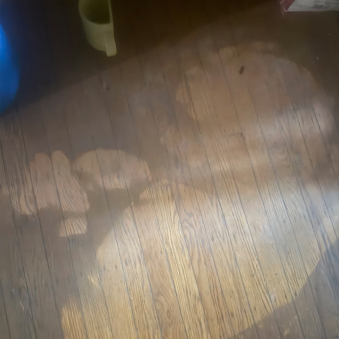 Dark smoke residue and soot stains on wooden flooring.