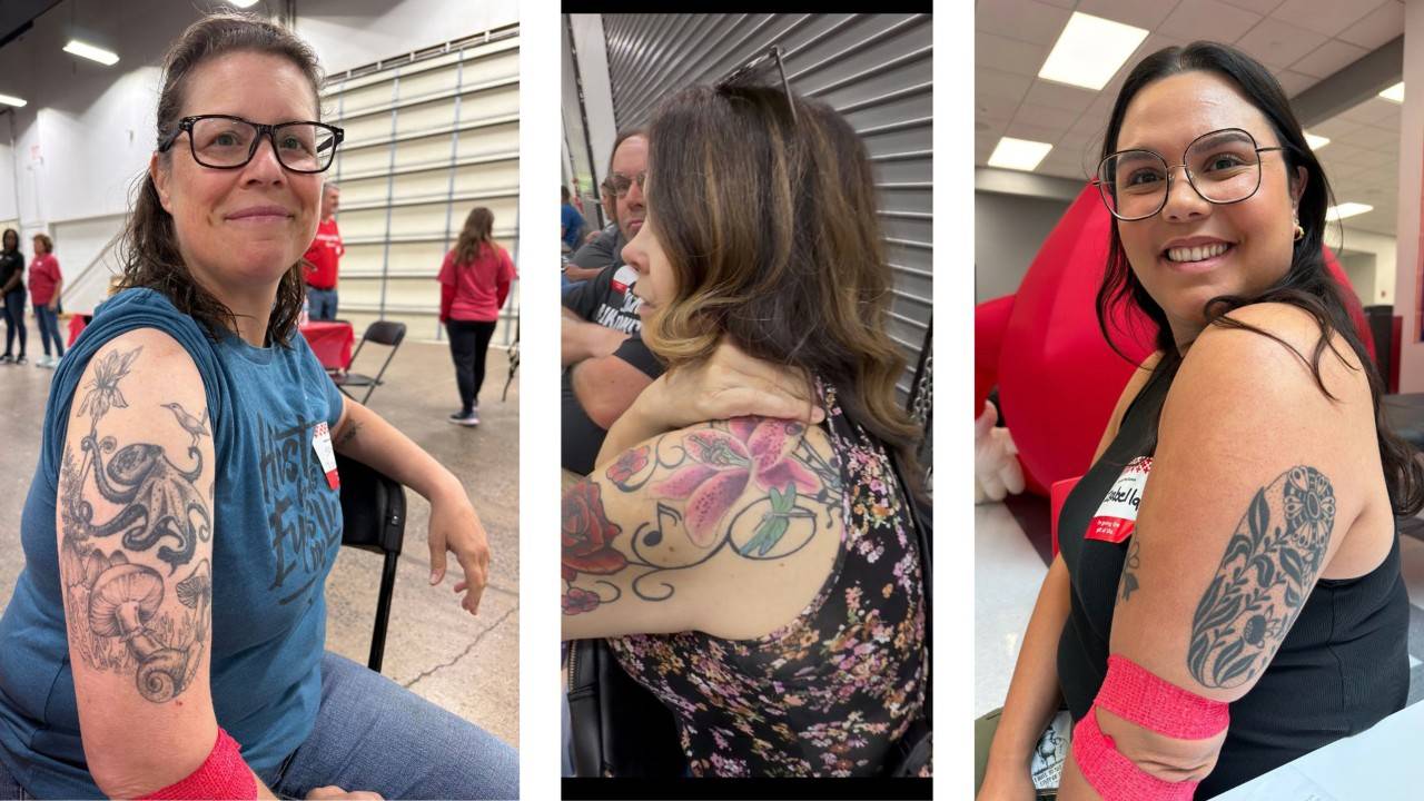 Three side-by-side photos show participants displaying upper-arm tattoos at an indoor event. The left photo features a detailed black-and-gray nature-themed sleeve with an octopus, mushrooms, flowers, a hummingbird, and a snail. The center photo shows a colorful tattoo with pink flowers, a dragonfly, musical notes, and decorative swirls across the shoulder and upper arm. The right photo features a bold black floral and leaf design on the upper arm. All three participants are seated indoors and wear bright pink bands around their forearms.