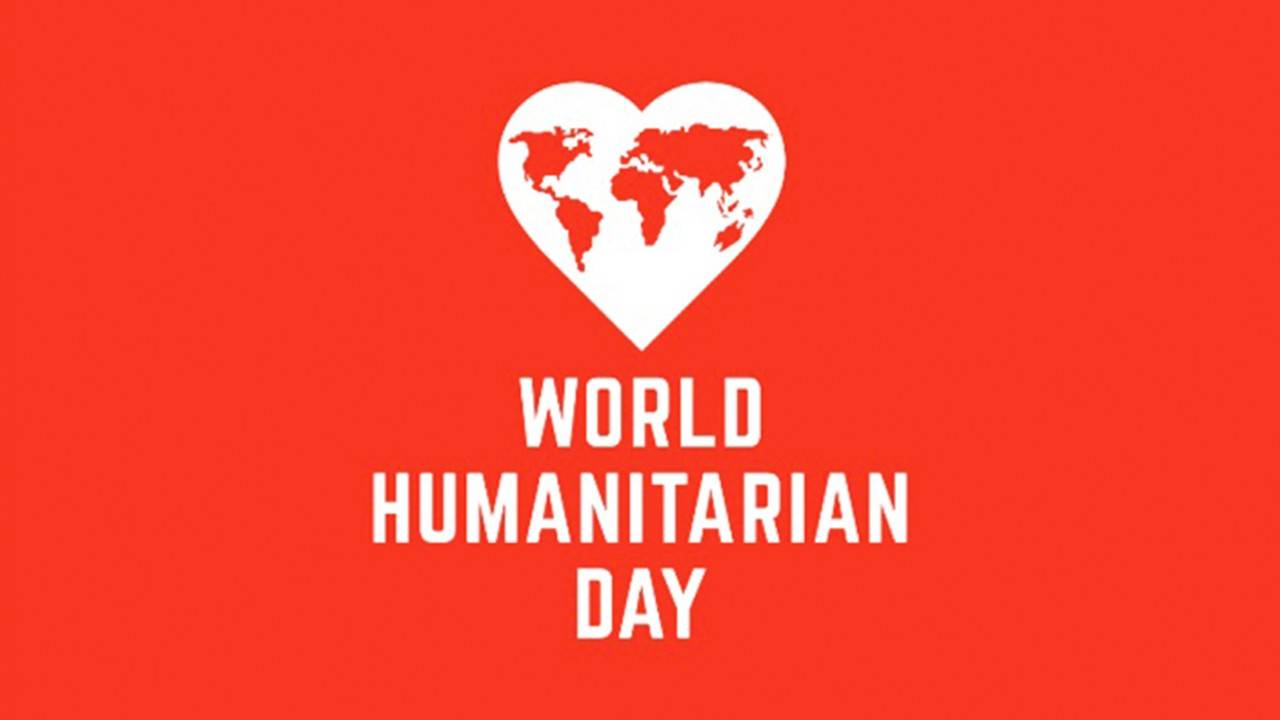 A graphic with a solid red background displaying a white silhouette of a heart containing a map of the world, positioned above the bold white text "WORLD HUMANITARIAN DAY".