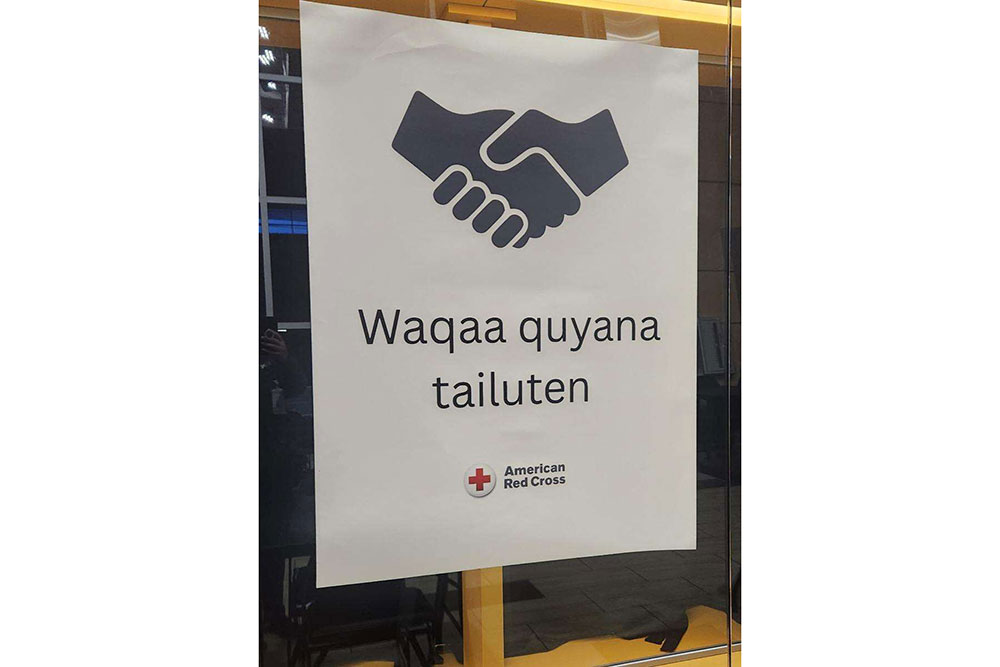 Red Cross sign with a handshake that says waqaa quyana tailuten..