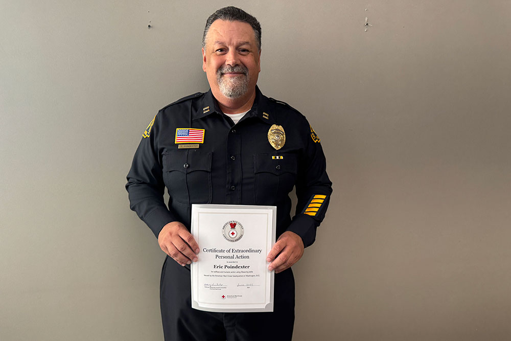 Eric Poindexter holds up the Red Cross award certificate he received.