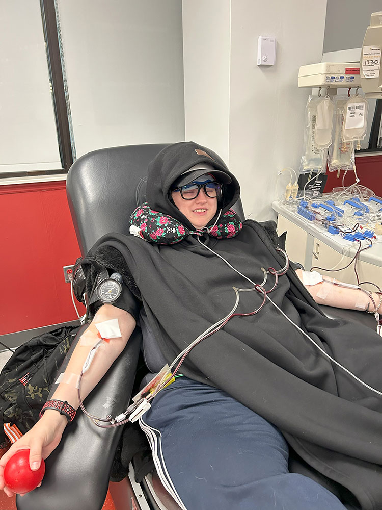 Christel Womack lying in chair and donating blood.