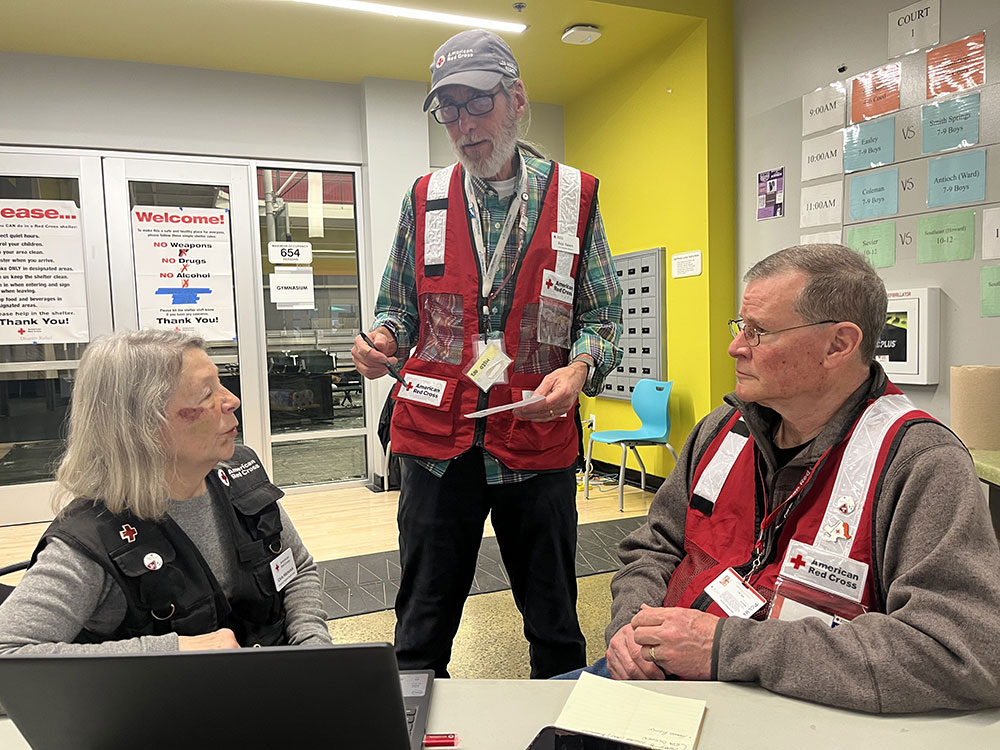 SRT volunteers Chris Hitchcock, Rick Yalem and Cliff Tash in an office talking to each other.