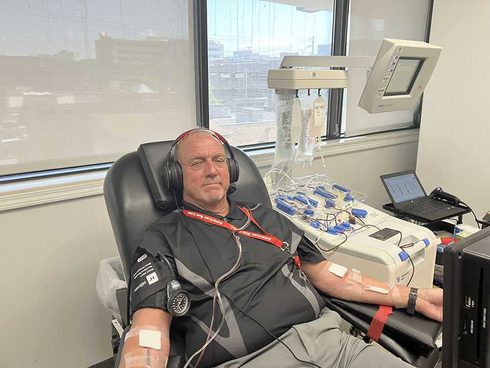 Gene Baker wearing headphones and sitting in chair while donating platelets at the Nashville Blood Donation Center.