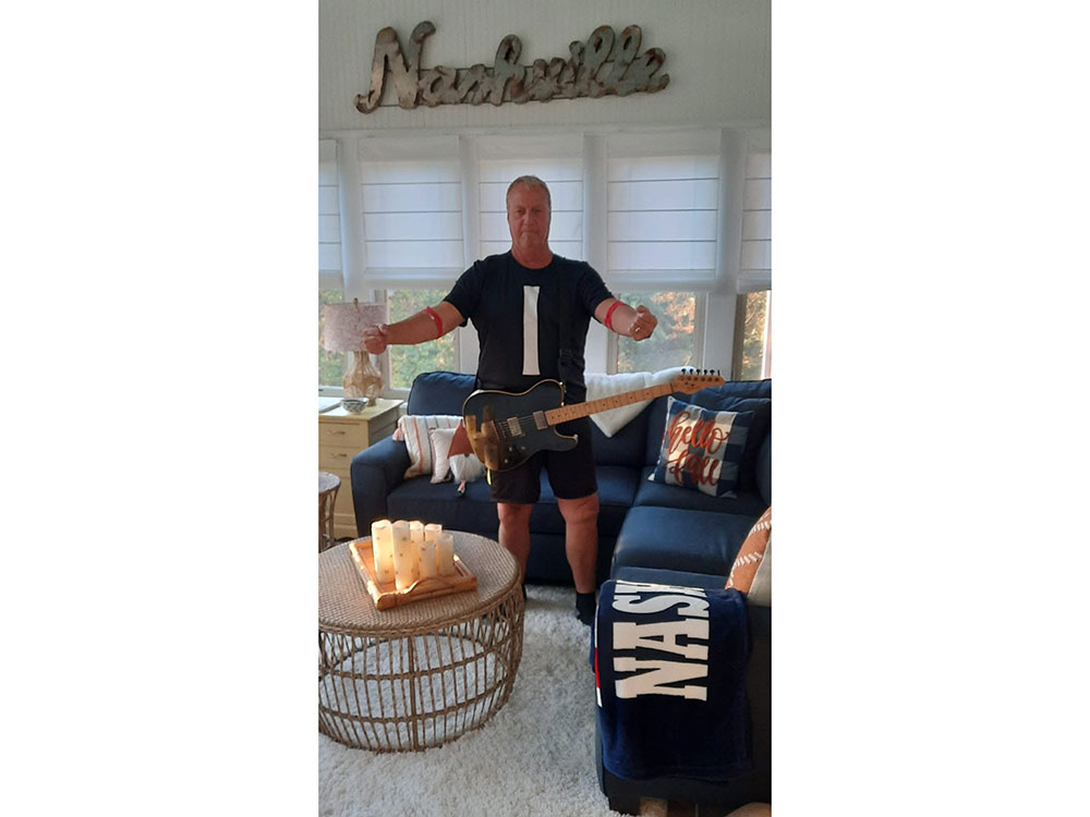 Gene shows off his red arm bands from donating platelets.