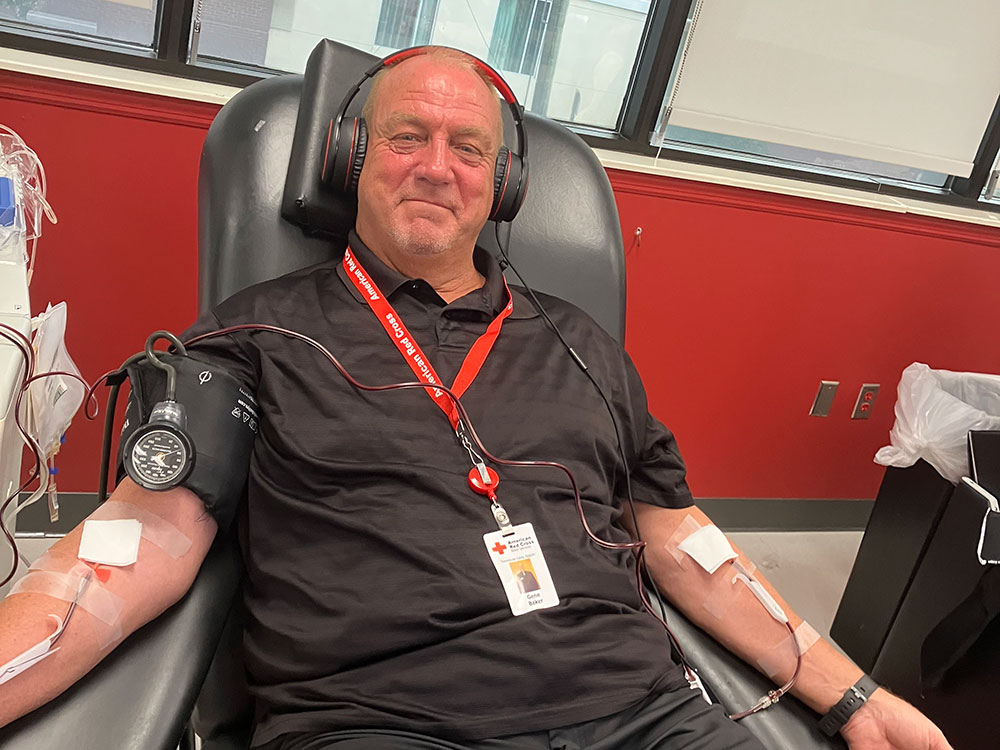 Gene Baker smiling and wearing headphones and sitting in chair while donating platelets at the Nashville Blood Donation Center.
