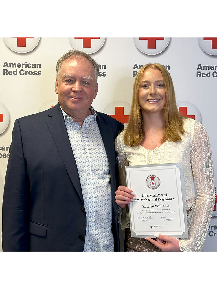 Katelyn Williams holding Red Cross award and standing next to Billy Austin at a Red Cross event.
