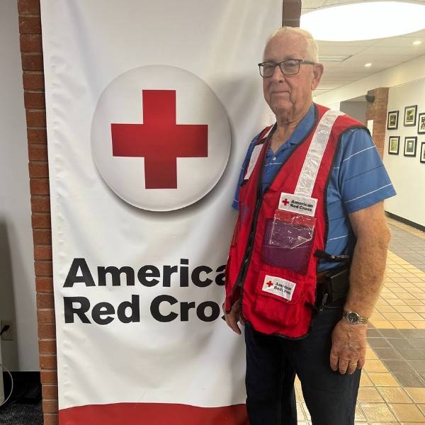 llyod standing next to a Red Cross sign.