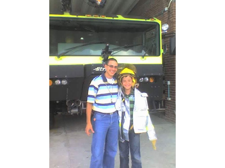 Javier and Camilo Riviere standing in front of a large truck.
