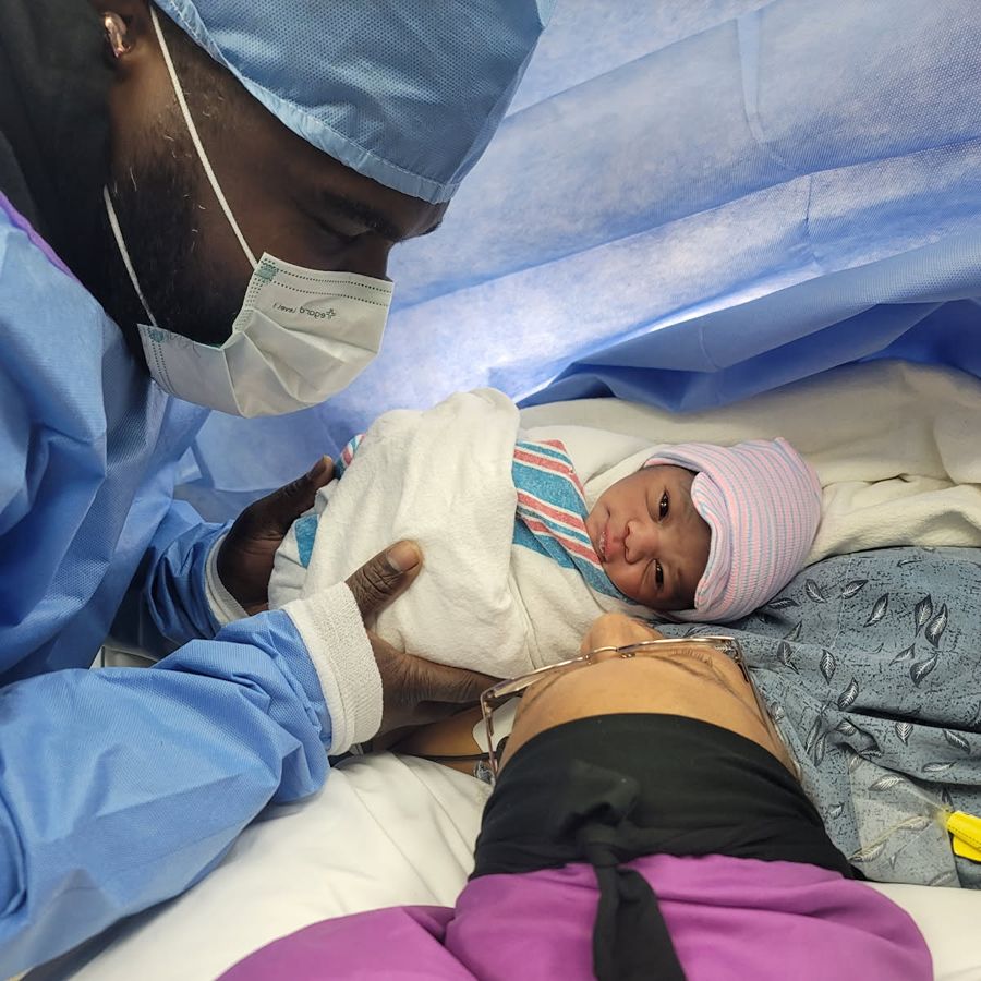 Toya's husband holding a baby in the hospital