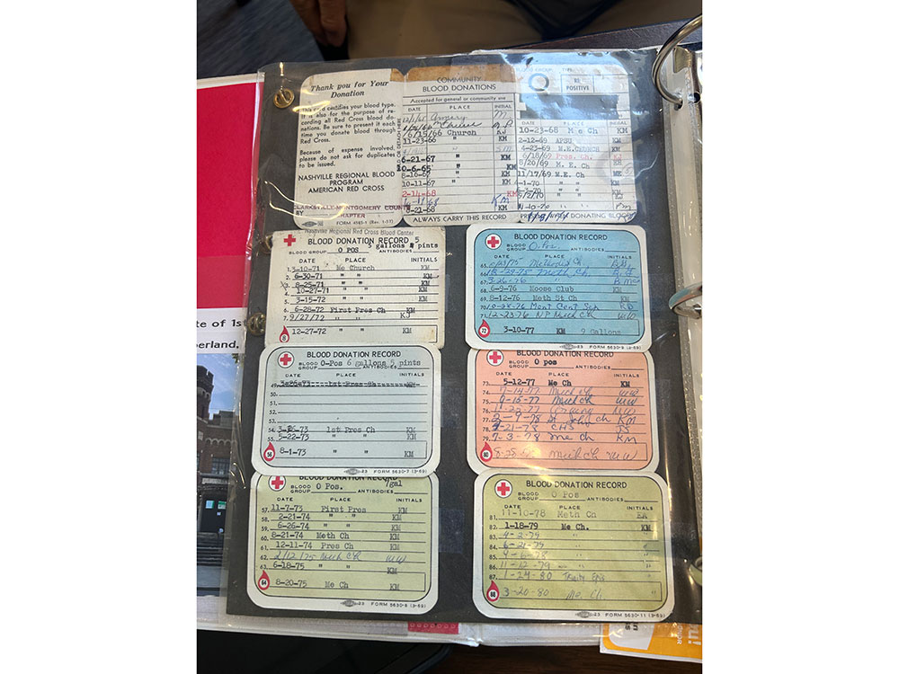 Ray Swadley's collection of vintage blood donation records in a binder sleeve. Cards display handwritten entries, stamps, and logos.