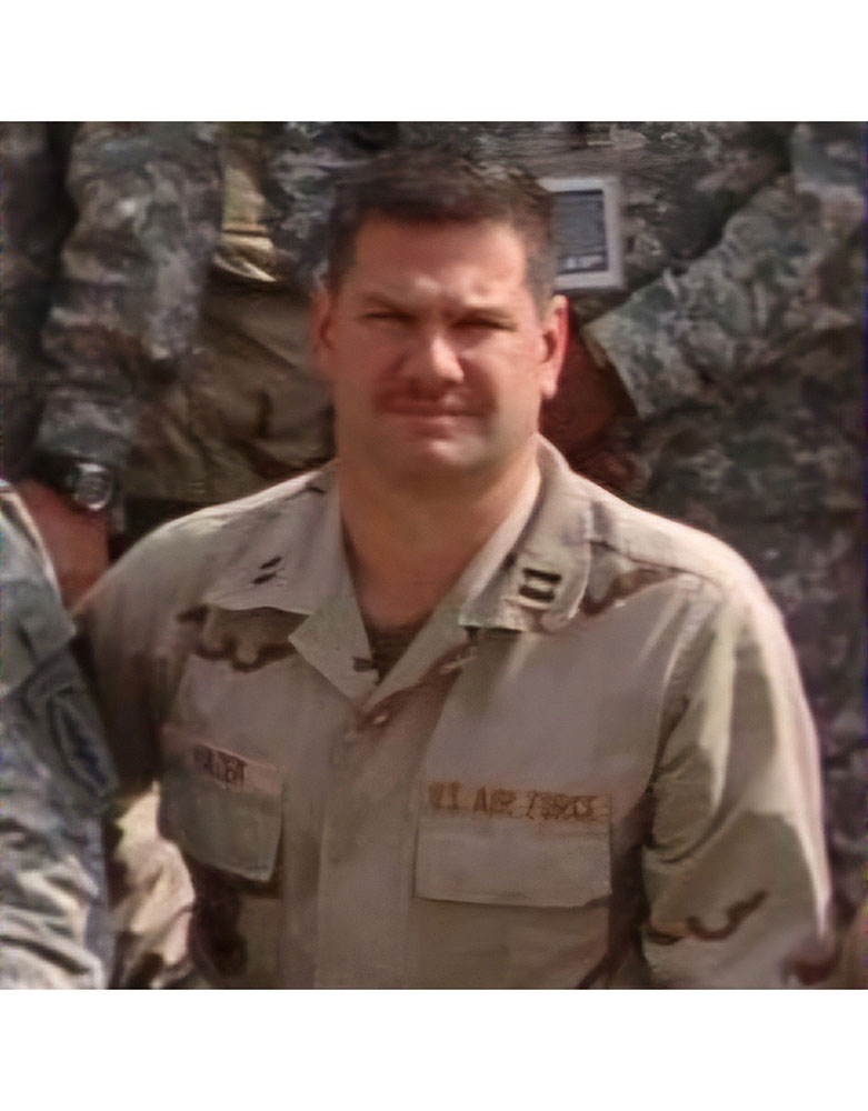 Stephen Kinzer in military uniform stands among fellow soldiers.