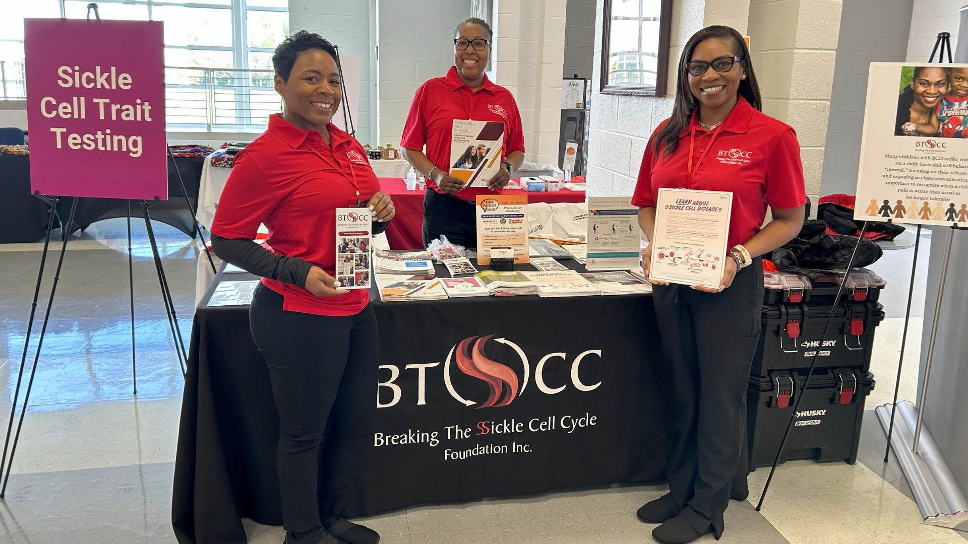 three women standing at sickle cell information table