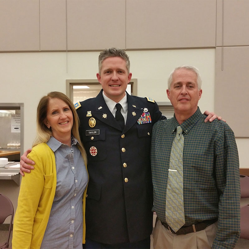 Military member with mother and father smiling for camera