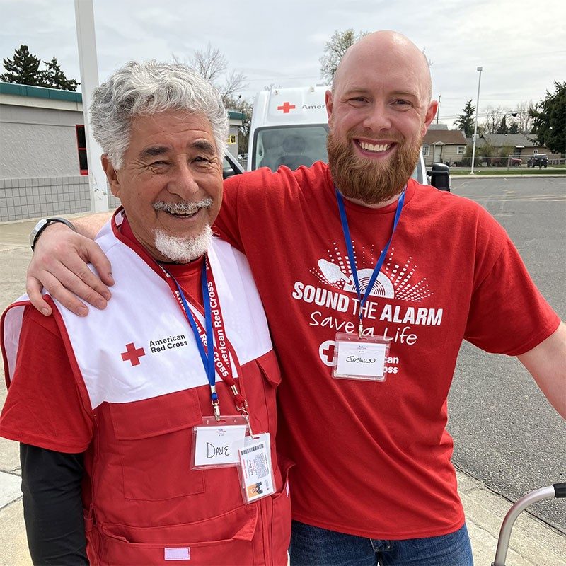 2 Red Cross volunteers smiling for camera