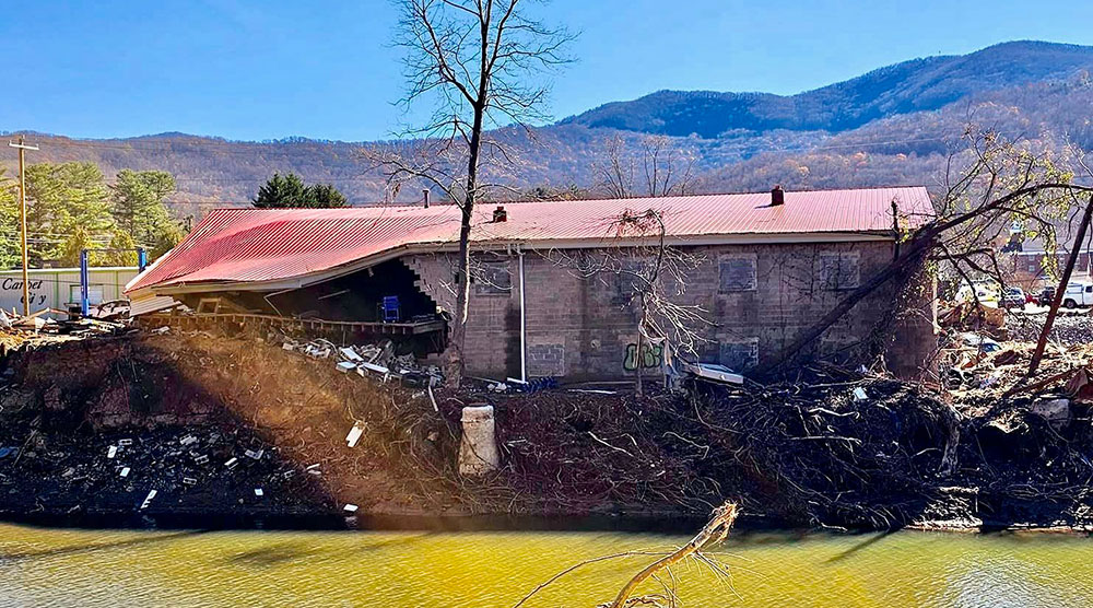 Damaged house by a body of water..