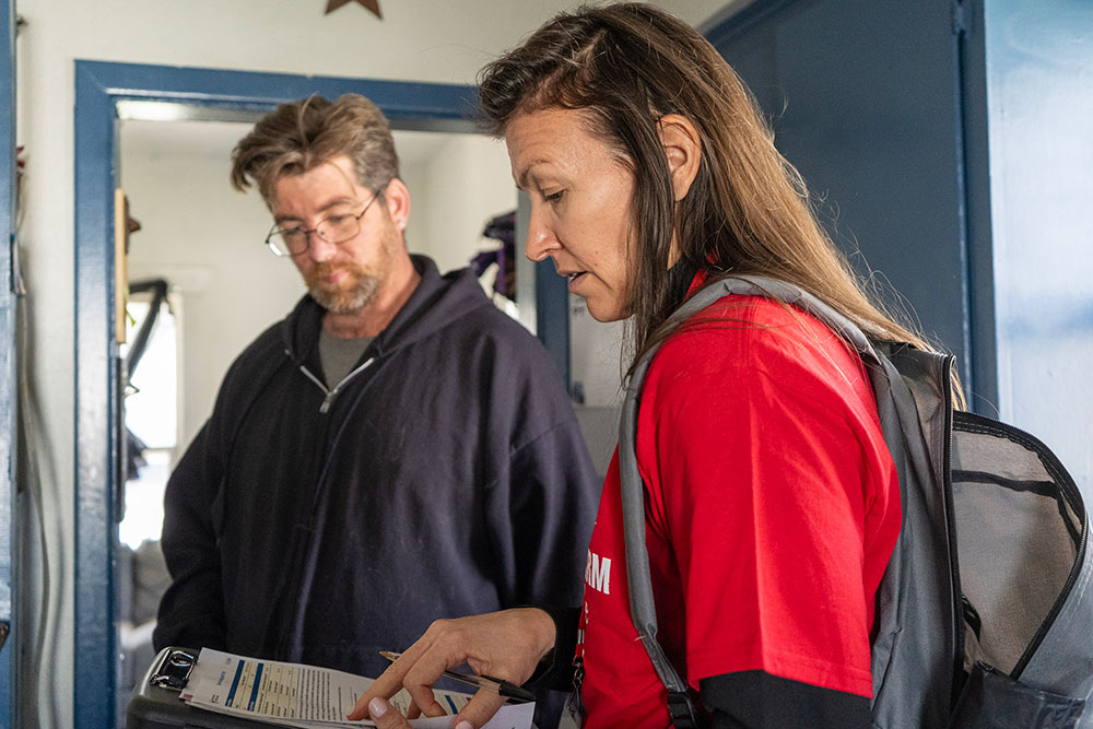 Red Cross volunteer looking at clipboard with David Pray.