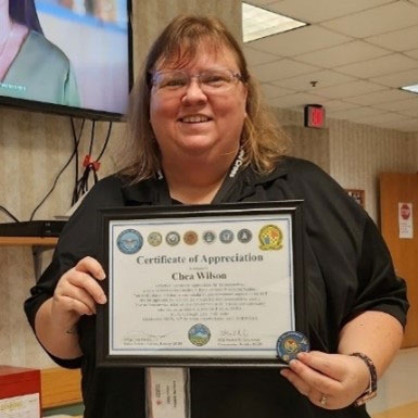 Chea Wilson holding Certificate of Appreciation.