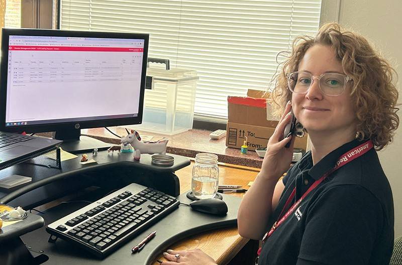 Woman holding a phone at a desk