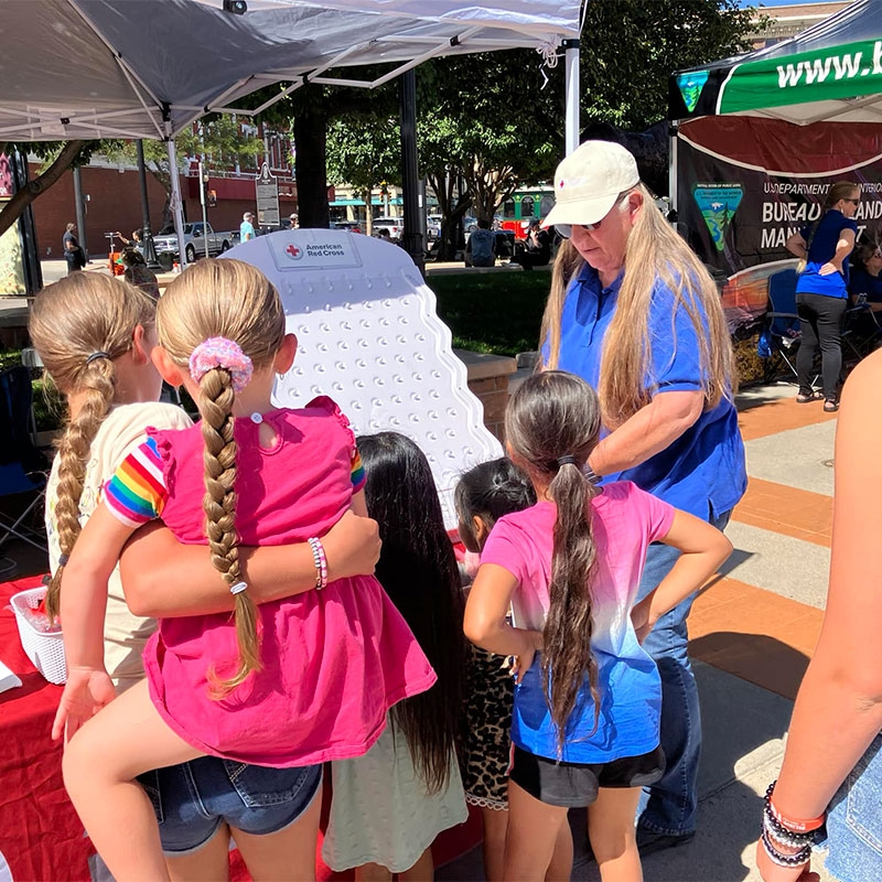 Mary Brown plays Plinko with attendees at the Cheyenne Hispanic Festival.