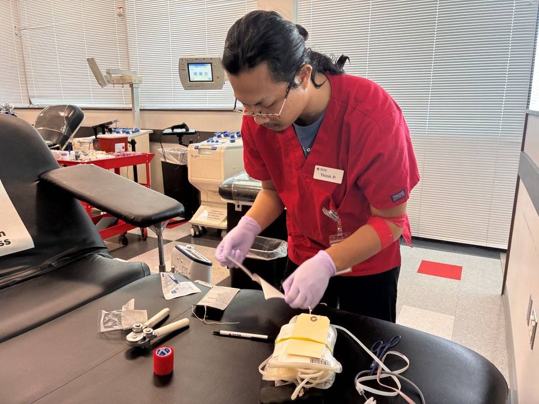 Phlebotomist organizes items on blood donation chair