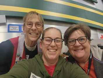 Three women in Red Cross shirts take selfie together