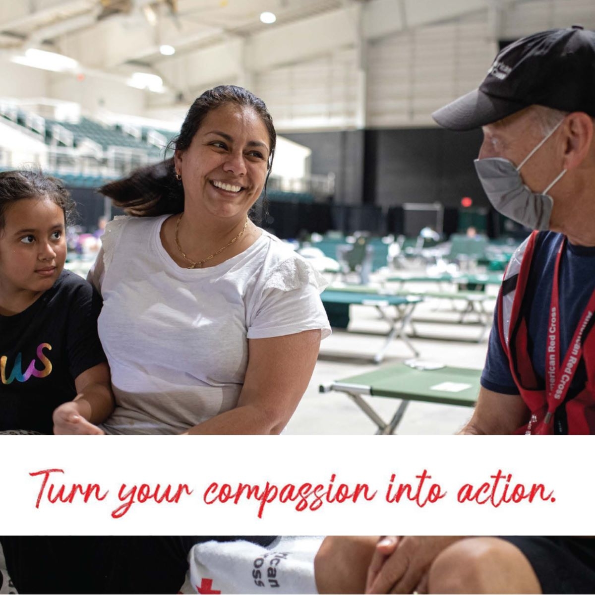 two people in shelter talking to red cross volunteer
