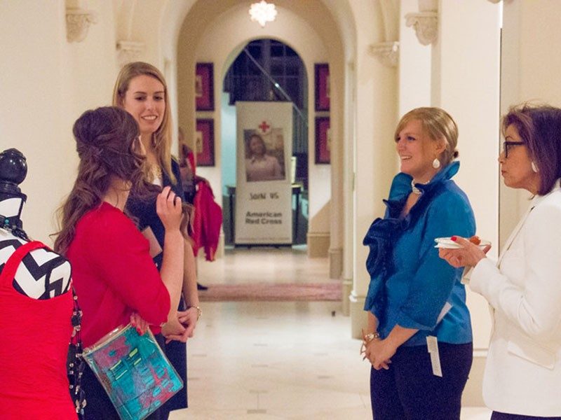 Tiffany Circle members speaking to each other in a hallway at the Shop for a Cause 2015 event..