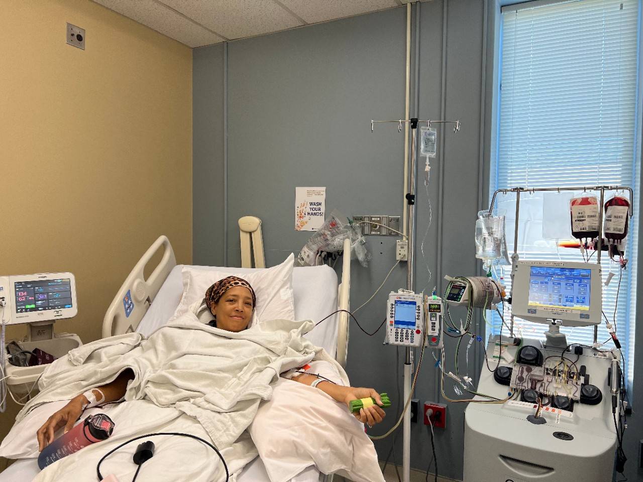 Woman lays in hospital bed while recieving blood transfusion