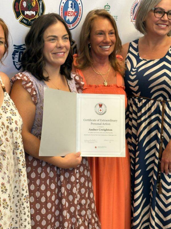 two women holding red cross certficate