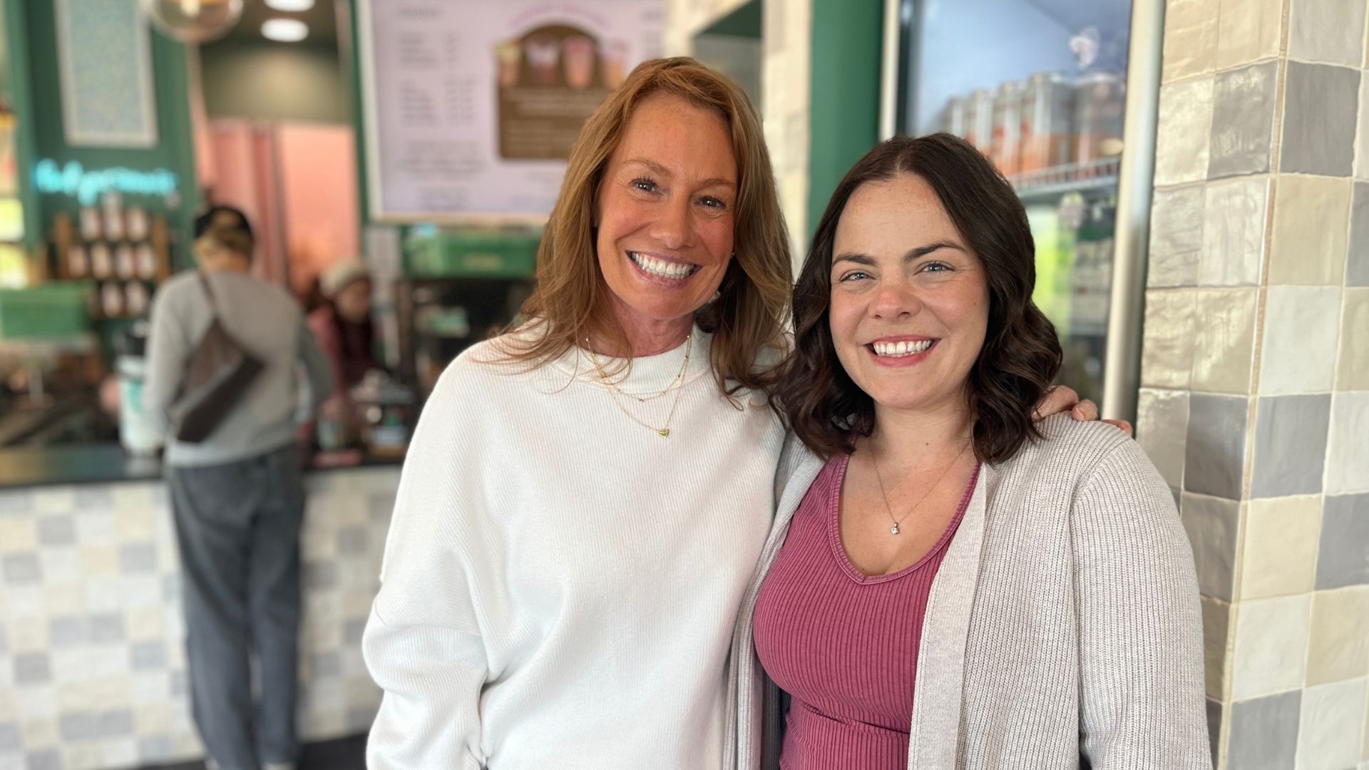 two women smiling at coffee shop