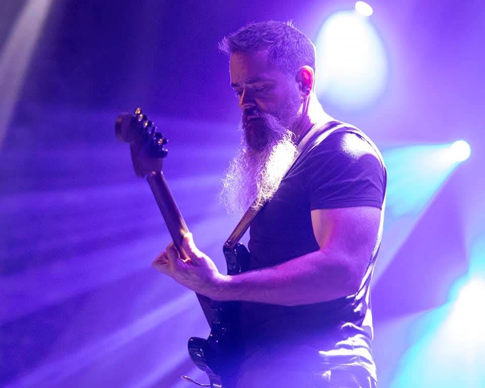 Man plays guitar on stage