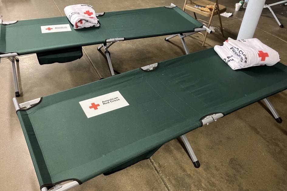 Red Cross cots and blankets inside a Red Cross shelter
