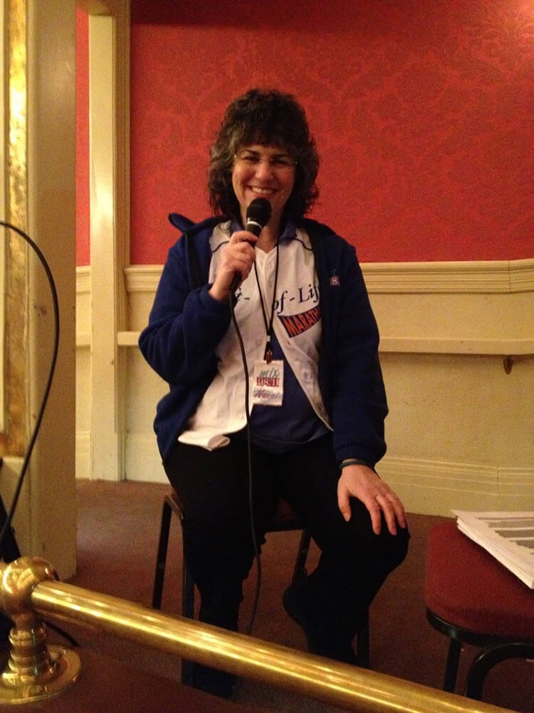 Nancy Gordon sitting in a chair and speaking into a mic.