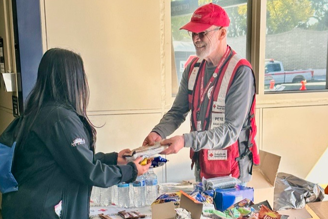 Red Cross volunteer hands out food during a disaster