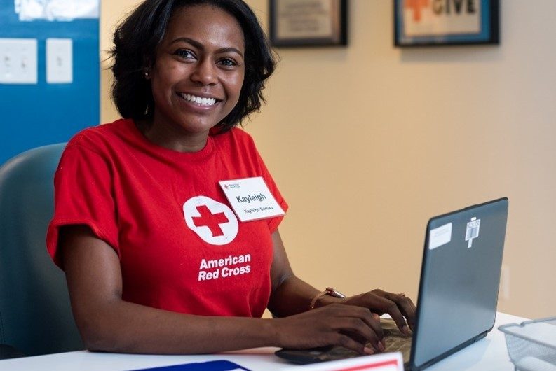 photo of female volunteer sitting at desk smiling