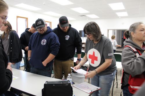 A group of Red CRoss volunteers huddle around a table.