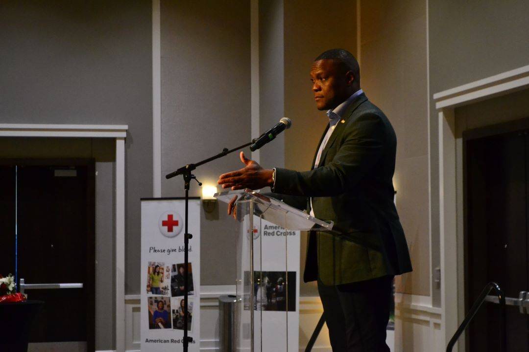 man at podium talking into microphone