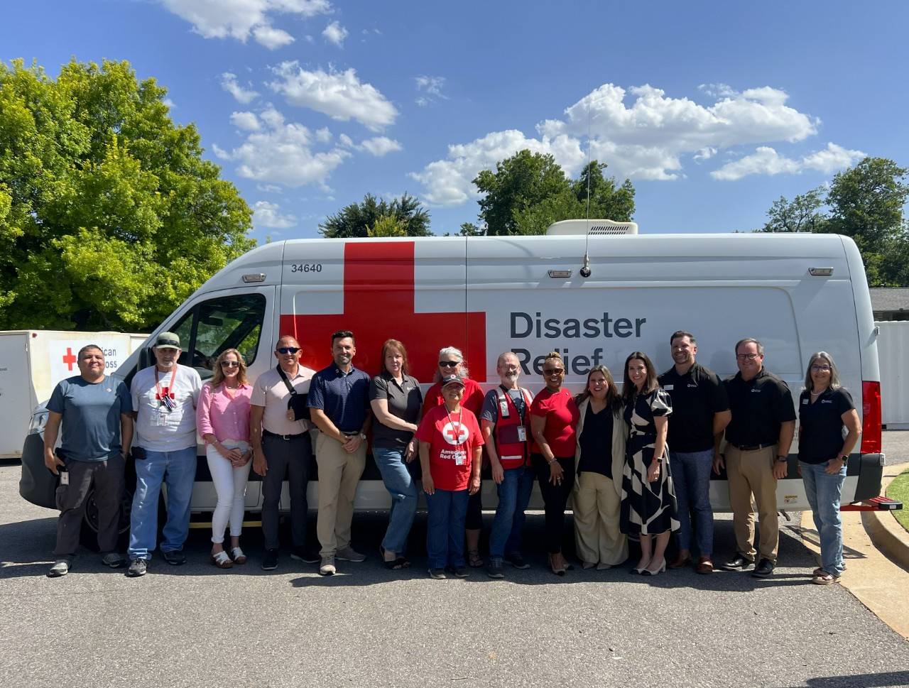 Group of people stand in front of Red Cross Disaster Relief vehicle