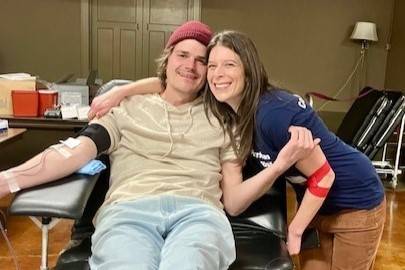 Woman hugs man in blood donation chair