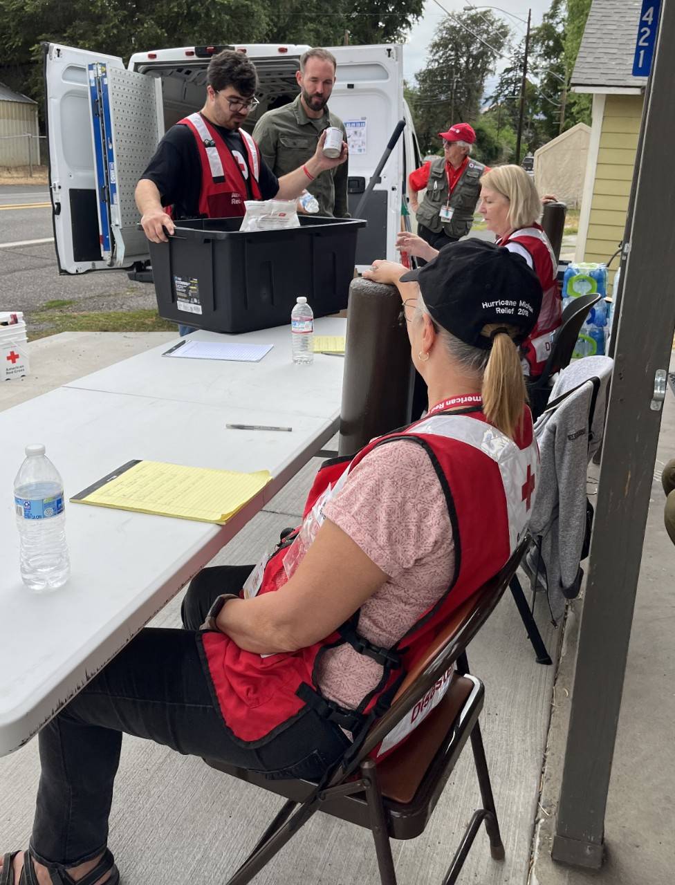 Red Cross Volunteers sorting goods at a table.