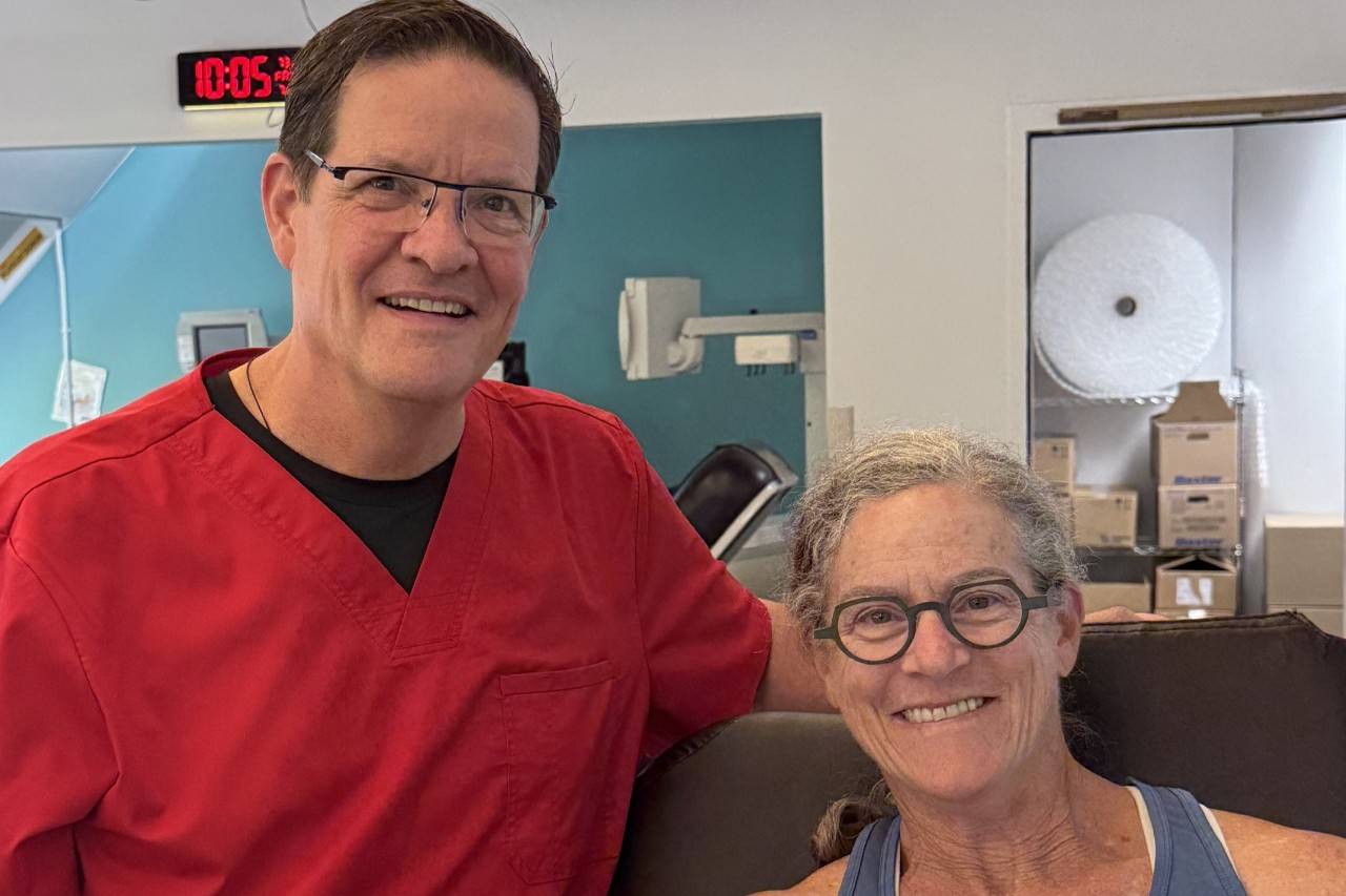 Phlebotomist stands next to blood donor