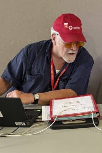 Red Cross volunteer works on computer