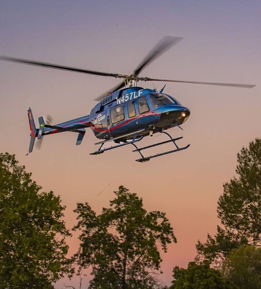 Helicopter flying above trees