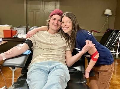 Woman hugs man in blood donation chair