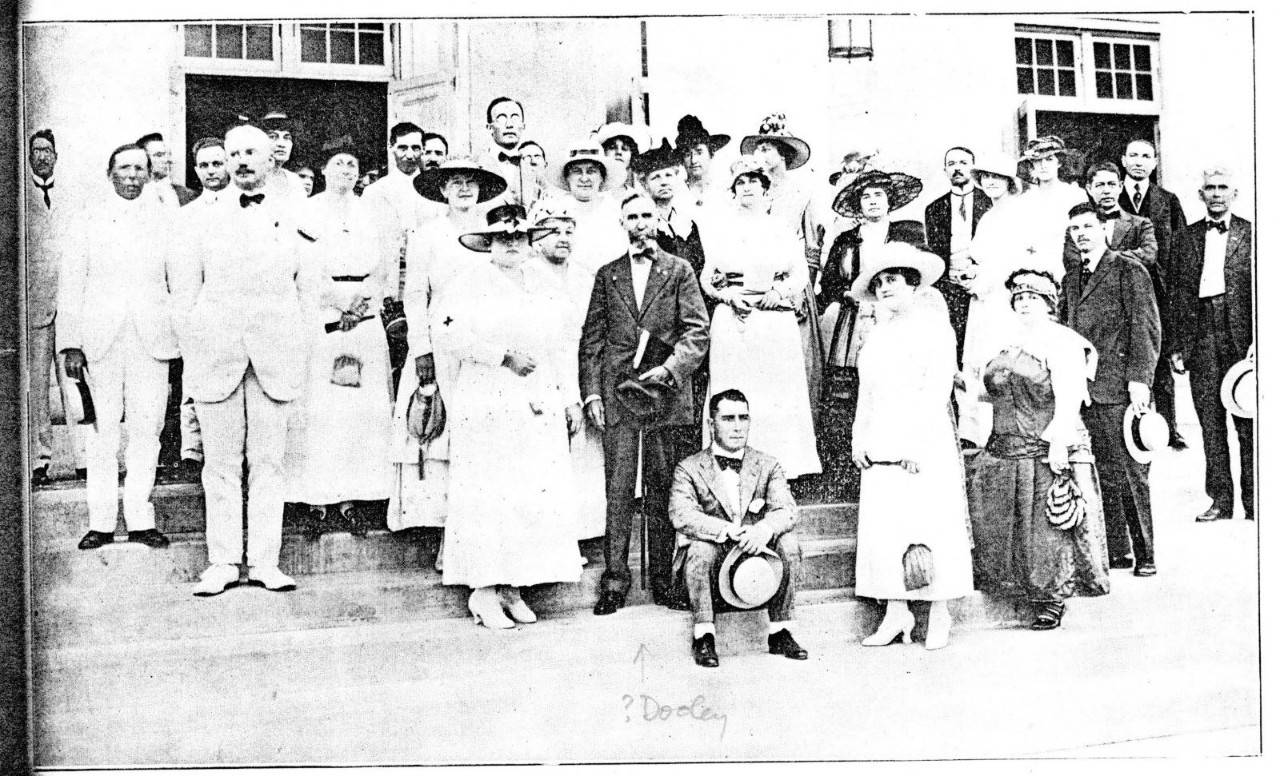 Un grupo de personas de pie frente a una biblioteca.