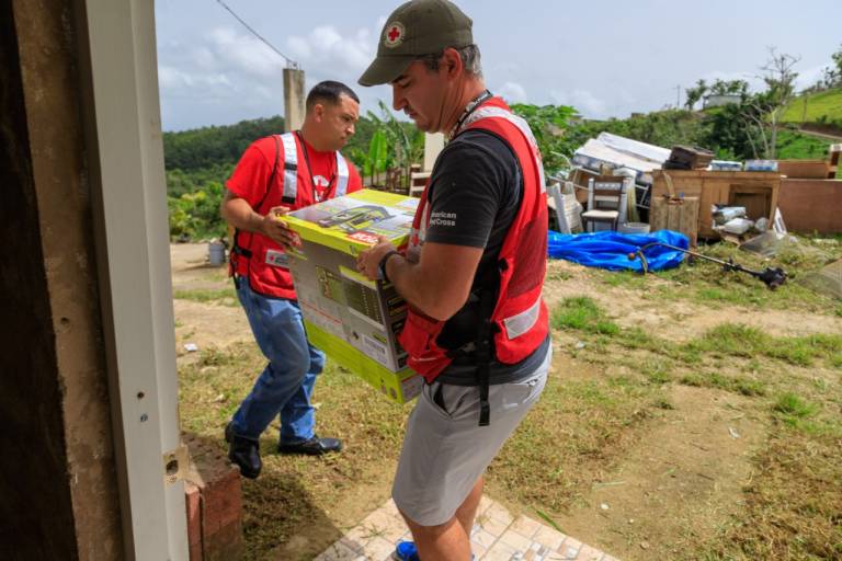 Fotografía de voluntarios de la Cruz Roja entregando un generador eléctrico.