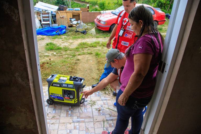Fotografía de voluntarios de la Cruz Roja entregando un generador eléctrico.