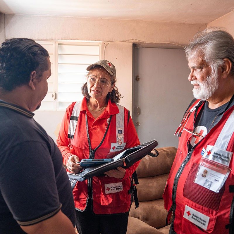 Voluntaria de la Cruz Roja explica plan de escape a clienta.