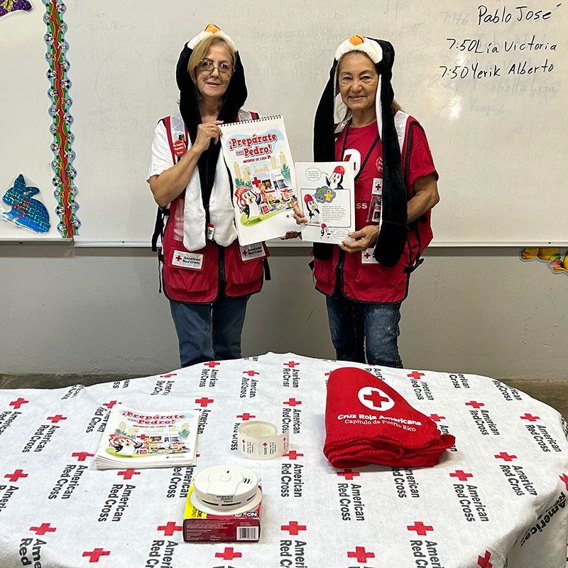 Voluntaria juvenil con sombrero de pingüino, brinda taller de preparación para niños llamado Prepárate con Pedro.